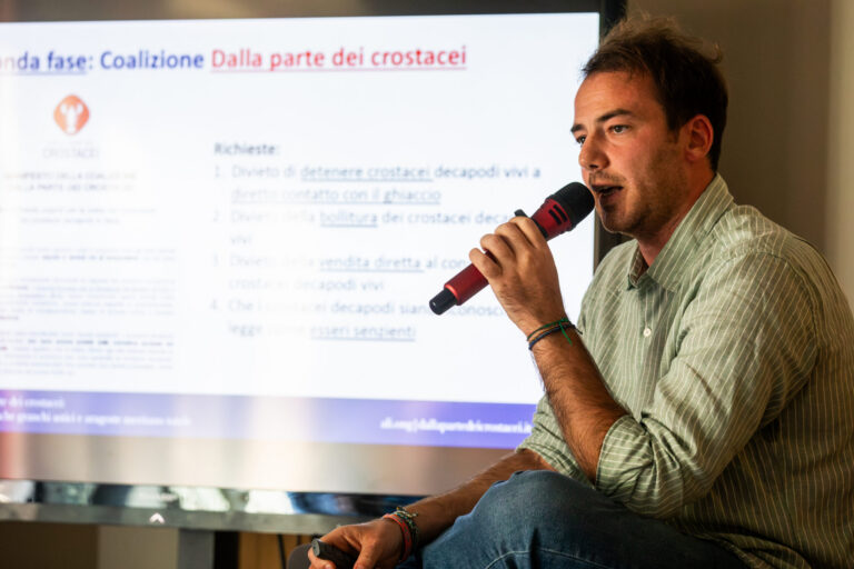 Un relatore parla al microfono durante l'evento Dalla parte dei crostacei a Milano